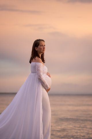 Smuk gravid i kjole ved vandet