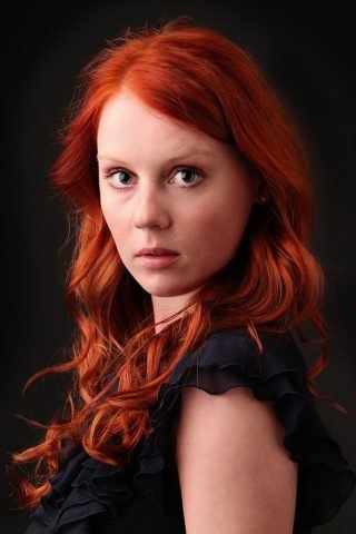 Studeieportræt af smuk rødhåret pige